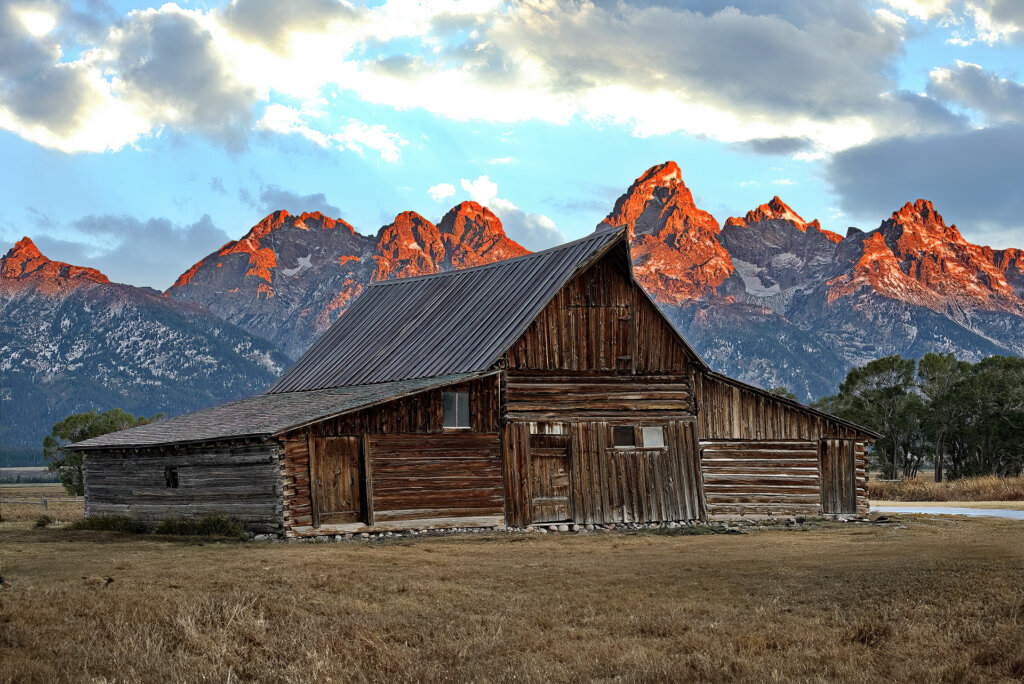 Famous TA-Moulton Barn on Mormon Row with a backdrop of the Grand Teton mountains at Sunrise - Copyright Randy G. Barney