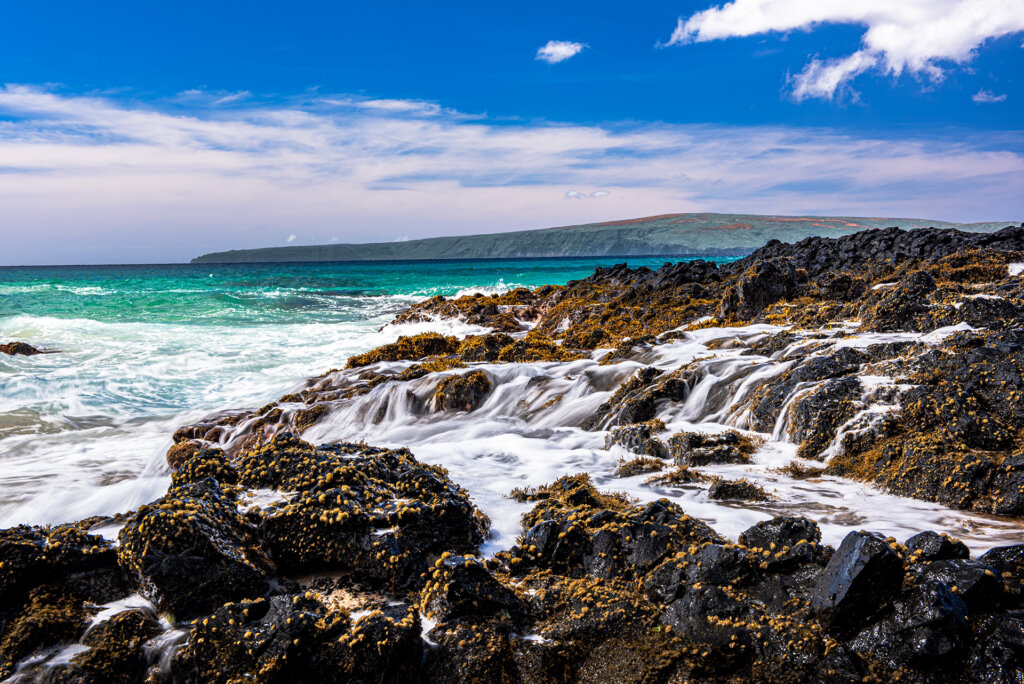 Lava rocks covered by the remnants of a wave in Secret Cove Beach on Maui - Copyright Randy G. Barney Photography